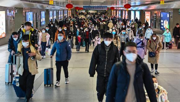 Los pasajeros llegan a la estación de tren de Hankou en Wuhan, en la provincia de Hubei, el 20 de enero de 2023, mientras la gente viaja a sus lugares de origen para las celebraciones del Año Nuevo Lunar. (Foto por Héctor RETAMAL / AFP)
