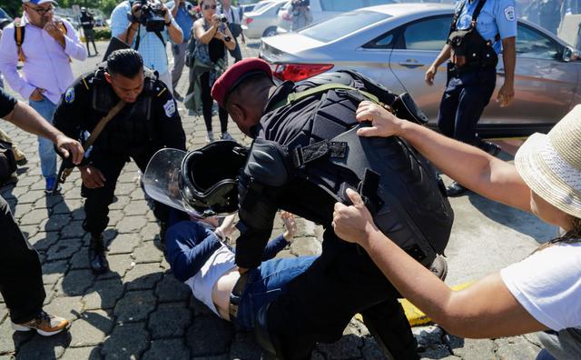 Los agentes policiales arrastraron por el pavimento a jóvenes, adultos y ancianos para llevarlos hasta los patrulleros del cuerpo de seguridad. (AFP).