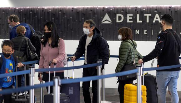 Los viajeros esperan en la fila en el check-in de Delta Airlines en el Aeropuerto Internacional de Los Ángeles, Estados Unidos, el 24 de diciembre de 2021, en plena pandemia de coronavirus. (DAVID MCNEW / AFP).