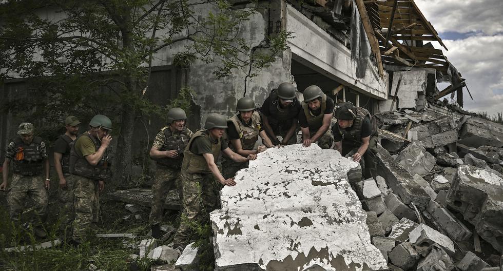 Soldados ucranianos inspeccionan un almacén destruido supuestamente atacado por tropas rusas en las afueras de Lysychansk, en la región de Donbas, en el este de Ucrania, el 17 de junio de 2022, cuando la guerra ruso-ucraniana entra en su día 114.