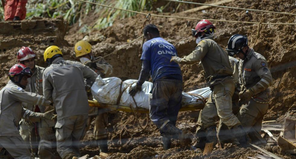 Bomberos cargan un cuerpo rescatado en el área de un deslizamiento de tierra provocado por fuertes lluvias en el barrio Jardim Monteverde de la ciudad de Jaboatão dos Guararapes, Brasil. (EFE/GENIVAL PAPARAZZI).