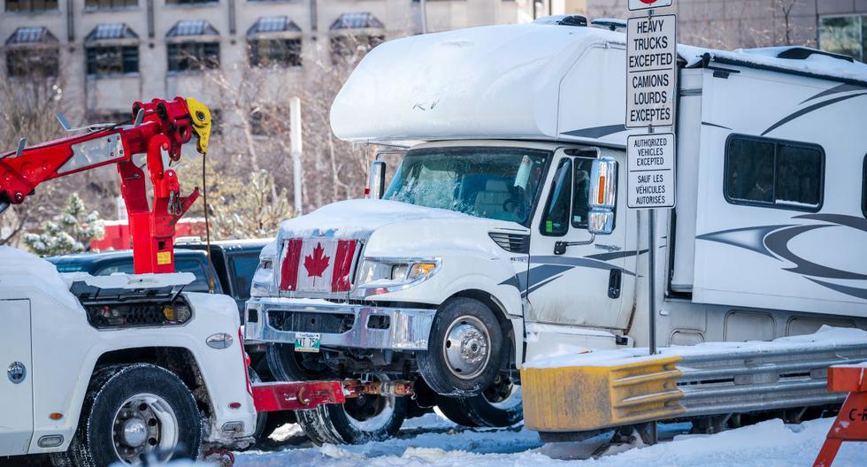 Un camión es remolcado cuando la policía comienza a despejar a los manifestantes contra los mandatos vacunación en Ottawa, Canadá, el 18 de febrero de 2022. (ANDREJ IVANOV / AFP).