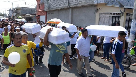 Familiares y amigos cargan los ataúdes de cuatro niños asesinados por hombres armados durante su funeral en Guayaquil, Ecuador, el 14 de diciembre de 2023. (Foto de Gerardo MENOSCAL / AFP)