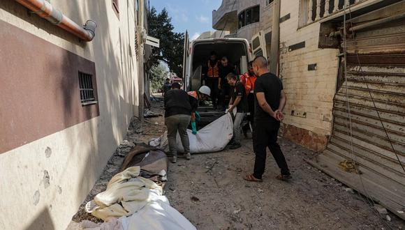Trabajadores palestinos de defensa civil junto a los cuerpos de algunos miembros de la familia Saqallah tras un ataque aéreo israelí en el suroeste de la ciudad de Gaza, el 19 de octubre de 2023 | EFE/EPA/MOHAMMED SABER