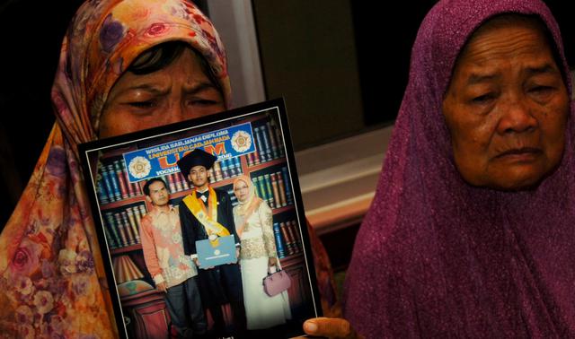 Las autoridades de Indonesia buscan con escasa esperanza supervivientes del avión de Lion Air que se estrelló en el avión. En la imagen, una madre muestra la foto de su hijo que iba en la nave. (Reuters).