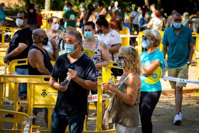 Un centenar de personas se congregaba el jueves frente a un puesto médico de campaña instalado en Ripollet, al norte de Barcelona, para hacer el despistaje gratuito de coronavirus. (EFE/ Enric Fontcuberta).