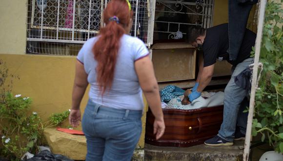 Coronavirus en Ecuador | Últimas noticias | Último minuto: Una mujer mira cómo el cadáver de su madre es colocado en un ataúd después de que ella muriera en su casa en Guayaquil. (REUTERS / Vicente Gaibor del Pino).