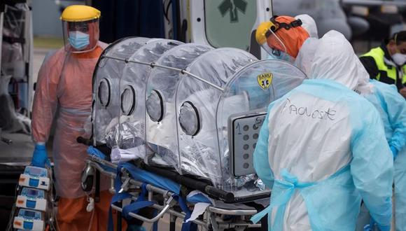 Personal sanitario de la Fuerza Aérea de Chile (FACH) e integrantes del Servicio de Atención Médica de Urgencia SAMU (de naranja) llevan a un avión a un paciente crítico de coronavirus COVID-19. (EFE/Alberto Valdés).