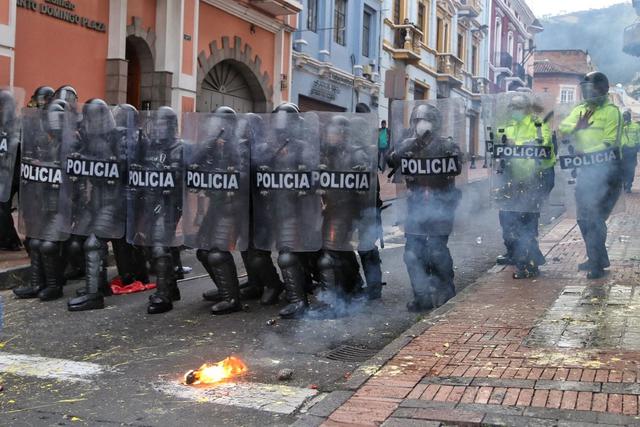 La policía antidisturbios bloquea una calle durante los enfrentamientos que siguieron a una marcha de organizaciones civiles, sociales y estudiantes en Quito, Ecuador. (CRISTINA VEGA RHOR / AFP).