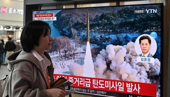 Una mujer pasa junto a una pantalla de televisión que muestra un noticiero con imágenes de archivo de una prueba de misiles norcoreanos, en una estación de tren de Seúl el 2 de abril de 2024. (Foto de Jung Yeon-je / AFP)