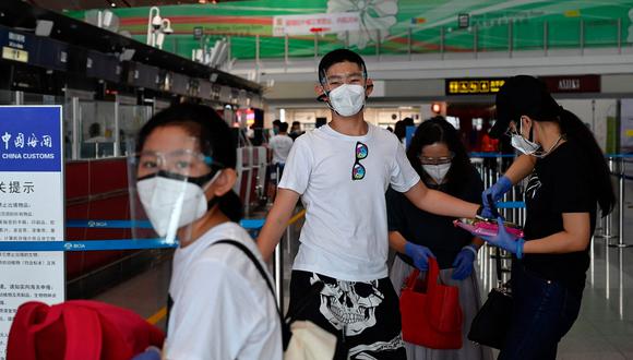 Un grupo de viajero llega al aeropuerto internacional de Beijing. (Foto: AFP)