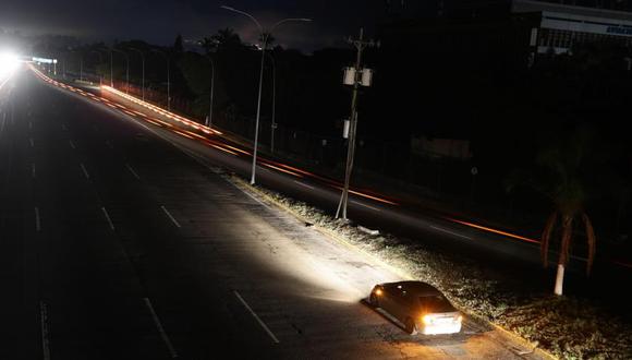 Vista de una carretera iluminada solo por los vehículos que la transitan debido a un apagón este lunes, en Caracas (Venezuela).  Foto: EFE