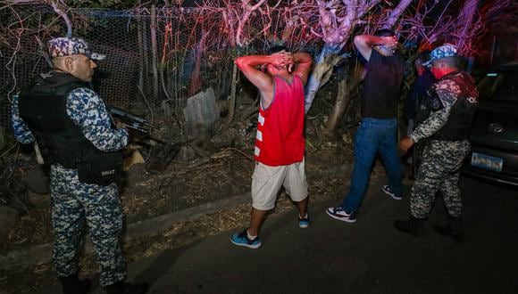 Fuerzas de seguridad cacheando a sospechosos durante una operación para rodear a los restos de pandillas en el sur de Chalatenango, al norte de El Salvador, el 24 de marzo de 2024. (Foto de Handout / Presidencia de El Salvador / AFP)