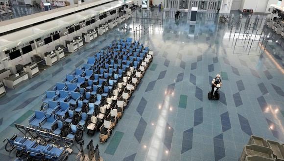Las sillas de ruedas están alineadas en un mostrador de facturación vacío del Aeropuerto Internacional de Tokio, Japón, el 3 de diciembre de 2021, en medio de la pandemia de coronavirus. (EFE / EPA / KIMIMASA MAYAMA).