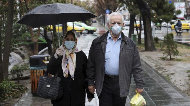 Los peatones usan máscaras para ayudar a protegerse contra el Coronavirus en el centro de Teherán. (Foto: AP).