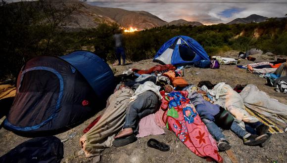 Migrantes venezolanos duermen a un costado de una carretera de Ecuador en su camino hacia el Perú. (AFP).