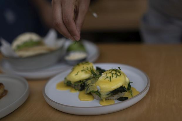 Benedictine eggs with smoked ham, vegetables such as spinach, poached eggs and hollandaise sauce.