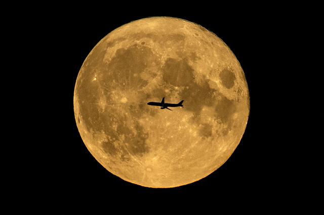 La silueta de un avión contra la luna llena en Moscú, el 22 de agosto de 2021. (Foto: Kirill KUDRYAVTSEV / AFP)