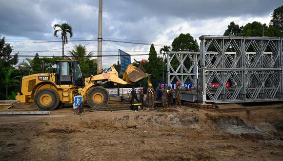 Soldados trabajan en la construcción de un puente temporal instalado sobre una carretera que colapsó por falta de mantenimiento y fuertes lluvias en Villa Nueva, Guatemala, el 14 de agosto de 2023 | Foto: JOHAN ORDONEZ / AFP