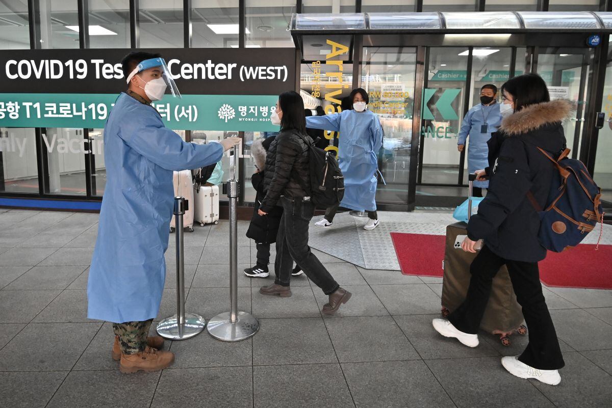 Health workers guide travelers arriving from China in front of a COVID-19 testing center at Incheon International Airport, west of Seoul, on Jan. 3, 2023. (Photo by Jung Yeon-je/ AFP)