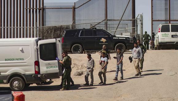 Migrantes detenidos son llevados por miembros de la Patrulla Fronteriza estadounidense a un vehículo, el 11 de mayo de 2023, junto al muro fronterizo en El Paso, Texas, EE.UU. (Foto de Jonathan Fernández / EFE)