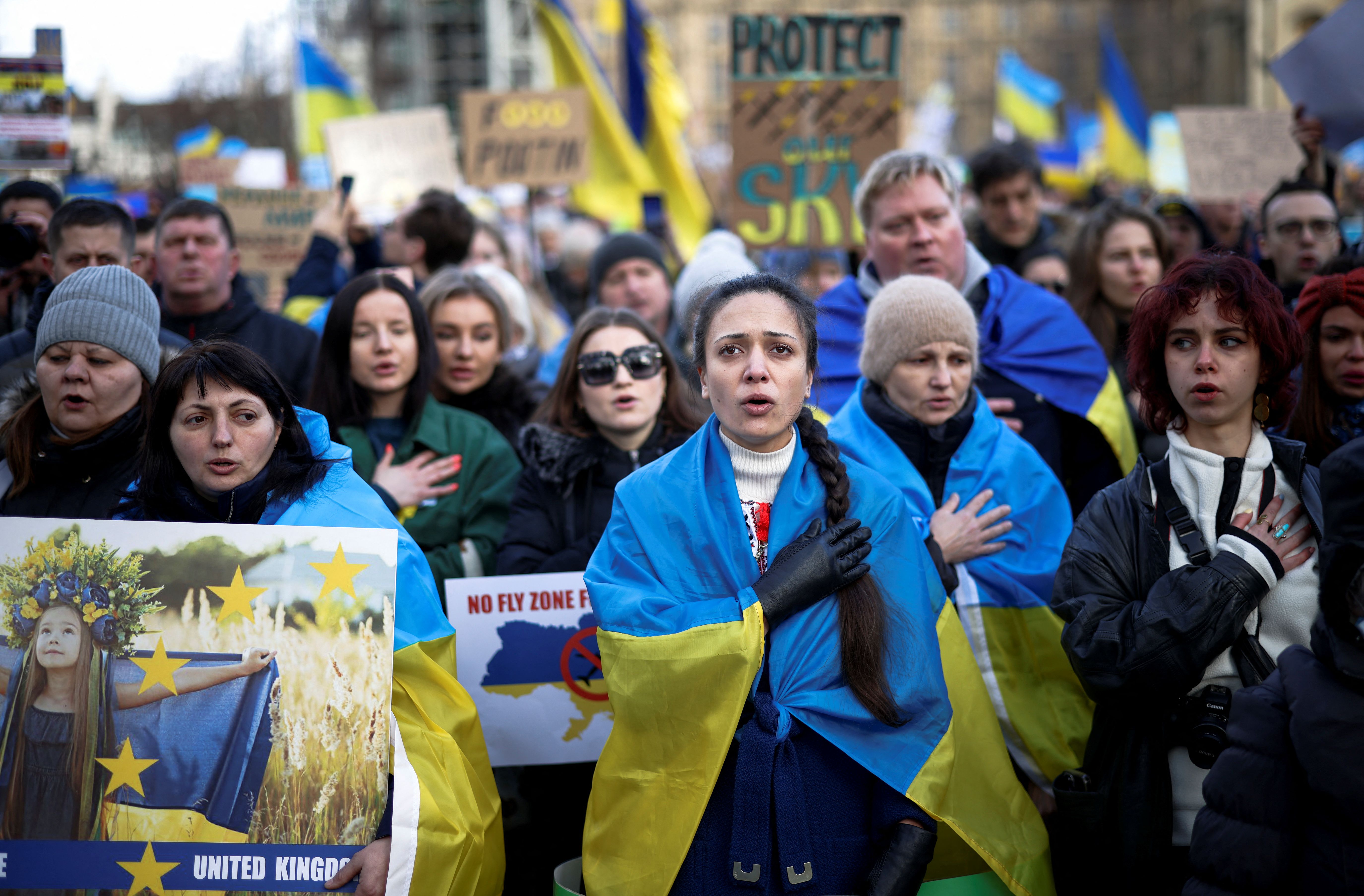 Demonstrators sing the Ukrainian national anthem during a protest against the Russian invasion of Ukraine, in Parliament Square in London, Britain.  (REUTERS/Henry Nicholls).