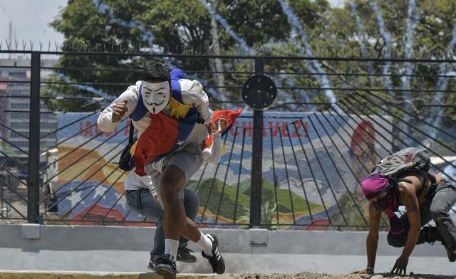 La Guardia Nacional arrojó gases lacrimógenos contra cientos de personas que intentaban bloquear una autopista en proximidades de la base aérea La Carlota, donde un grupo de militares se sublevó contra Nicolás Maduro. (AFP).