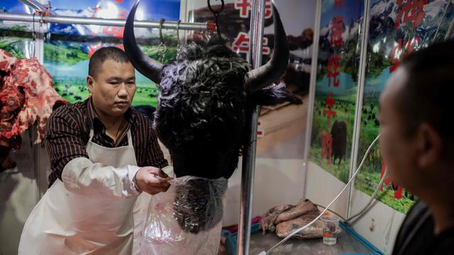 En esta fotografía captada el 15 de enero se ve a un comerciante alistando una cabeza de yak que acaba de ser comprada en un mercado húmedo de Beijing, China. Por esa fecha, la OMS ya apuntaba a que el origen del COVID-19 era animal y las autoridades chinas señalaban al mercado de Huanan, en Wuhan, como el disparador del brote. (Foto: Nicolas Asfouri / AFP)