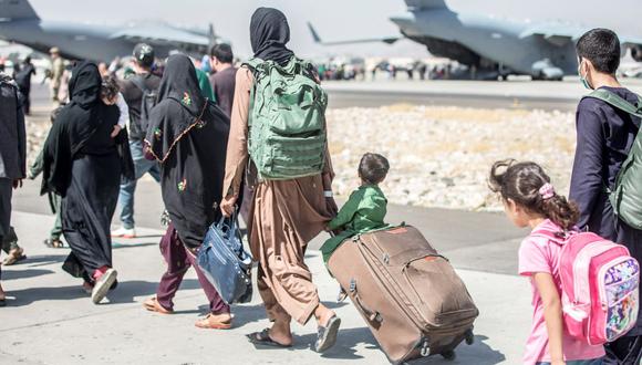 Un grupo de afganos se dirige hacia un avión durante una evacuación en el Aeropuerto Internacional Hamid Karzai, en Kabul, Afganistán, el 24 de agosto de 2021. (SAMUEL RUIZ / US MARINE CORPS / AFP).