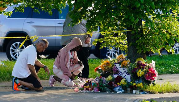 Las personas se inclinan ante un altar colocado cerca del lugar de la masacre en un supermercado de Buffalo. (Foto AP/Matt Rourke).