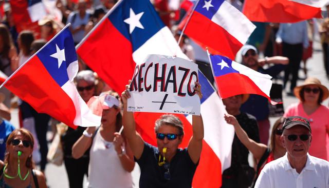 La mayoría de los manifestantes, vecinos de este barrio, protestó de forma pacífica sin interrumpir el tránsito vehicular, portando pancartas con la frase “rechazo” y banderas chilenas mientras gritaban consignas en contra de la izquierda chilena.  (Foto: EFE).