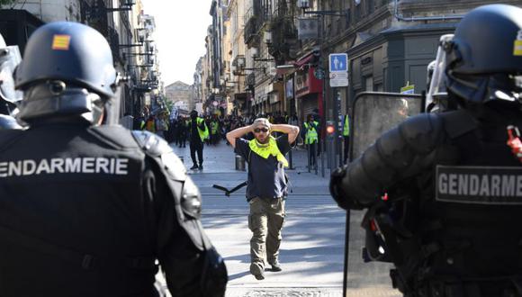 Un manifestante se enfrenta a gendarmes antidisturbios durante una manifestación como parte de un vigésimo sábado consecutivo de protestas convocadas por el movimiento de los "chalecos amarillos" (gilets jaunes) en Burdeos, en el oeste de Francia. (Foto: Archivo/ MEHDI FEDOUACH / AFP).