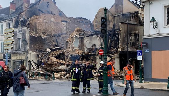 Personal de emergencia examina la escena de un edificio incendiado, que albergaba una farmacia, en Montargis, a unos 100 km al sur de París, el 1 de julio de 2023. (Foto de Mathieu RABECHAULT / AFP)