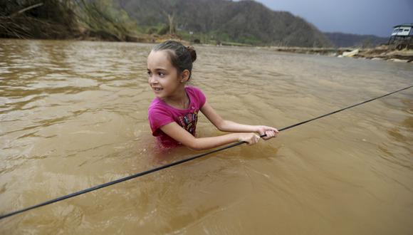 Puerto Rico. Muchos lugares siguen inundados pese a que ya pasó una semana del huracán. En la imagen, una niña en la ciudad de Morovis. (AP)