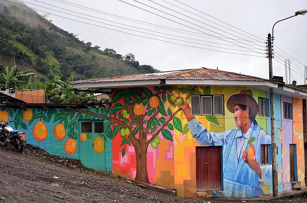 Mural denominado Agricultora Naranja. Fue pintado en el 2013, en el distrito de Yanatile, Cusco, como parte de un voluntariado en la ciudad. La modelo de la pintura es la propietaria de la vivienda.