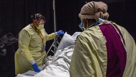 Los trabajadores sanitarios atienden y consuelan a un paciente de coronavirus Covid-19 en el Hospital UMASS Memorial DCU Center en Worcester, Massachusetts, el 13 de enero de 2021. (Foto de Joseph Prezioso / AFP).