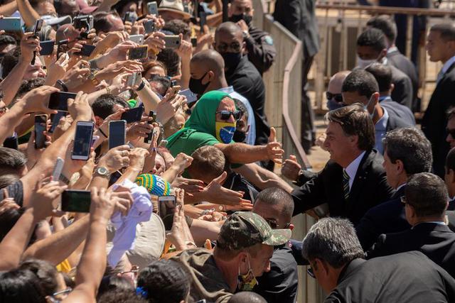Como es usual, el líder de la ultraderecha brasileña se acercó a los asistentes una vez que concluyó la ceremonia, saludó a muchos, posó para fotografías e ignoró las medidas de prevención que impone el coronavirus. (Foto: EFE/ Joédson Alves)