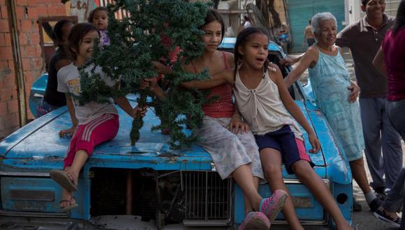 Niños en una barriada en Caracas juegan con un arbolito de Navidad. 85 % de venezolanos pasan trabajos para la cena navideña y los regalos. Foto: EFE, vía El Tiempo de Colombia/ GDA