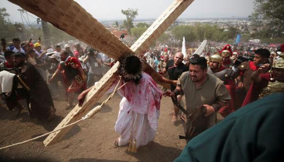Axel Eduardo González Bárcenas lleva la cruz de madera mientras representa a Jesucristo en el barrio de Iztapalapa como parte de la celebración de la Semana Santa en la Ciudad de México, México.