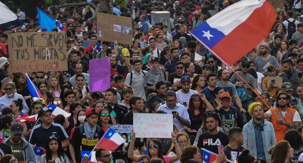 People demonstrate in Santiago, on October 25, 2019, a week after violence protests started. Demonstrations against a hike in metro ticket prices in Chile's capital exploded into violence on October 18, unleashing widening protests over living costs and social inequality. / AFP / Martin BERNETTI