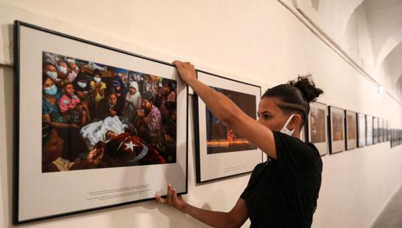 Un trabajador cuelga fotos para la exposición "Fotógrafo anónimo en Myanmar" realizada para The New York Times antes de la 33ª edición del festival internacional de fotoperiodismo Visa pour l'Image, en Perpignan, sur de Francia. (Foto de RAYMOND ROIG / AFP).
