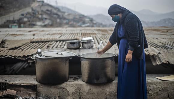 Una mujer prepara comida en Pamplona Alta, al sur de Lima, durante la nueva pandemia de coronavirus. (Foto: ERNESTO BENAVIDES / AFP).