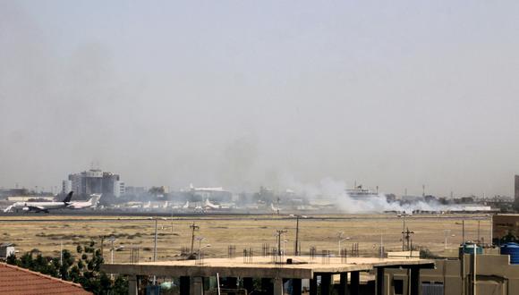 Se puede ver humo en la pista del aeropuerto de Jartum el 15 de abril de 2023, en medio de enfrentamientos en la capital sudanesa. - Las explosiones sacudieron la capital sudanesa el 15 de abril cuando los paramilitares y el ejército regular intercambiaron ataques entre sí, días después de que el ejército advirtiera que el país estaba en un punto de inflexión "peligroso". (Foto por AFP)