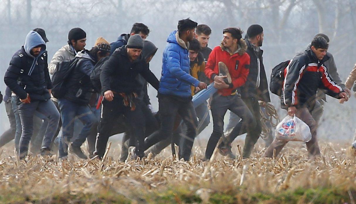 Los migrantes llevan a un hombre herido cerca del cruce fronterizo de Pazarkule en Turquía con Kastanies en Grecia, después de que la policía de Grecia lanzó gases lacrimógenos contra ellos. (Reuters).