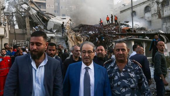 El ministro de Asuntos Exteriores sirio, Faisal Miqdad (centro), visita el lugar de los ataques que alcanzaron un edificio anexo a la embajada iraní en la capital de Siria, Damasco, el 1 de abril de 2024. (Foto de LOUAI BESHARA / AFP)
