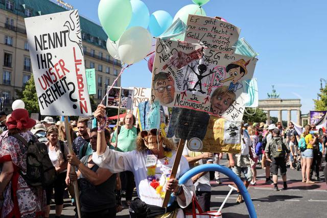 Algunos manifestantes sostienen pancartas donde acusan a Bill Gates de estar detrás del coronavirus. (REUTERS/Fabrizio Bensch).