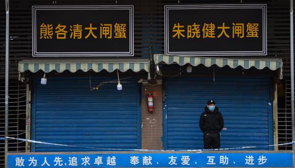 Un guardia de seguridad resguarda el mercado mayorista de mariscos de Huanan, en Wuhan, donde se detectó el coronavirus. (Foto de Hector RETAMAL / AFP).