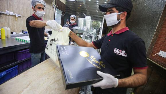 Los clientes también deberán tener equipos de protección para ser atendidos. (Foto de AHMAD AL-RUBAYE / AFP)