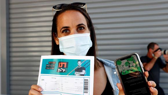 Una mujer muestra su "pase verde" (prueba de estar completamente vacunada contra el coronavirus COVID-19) a su llegada al Estadio Bloomfield en Tel Aviv, Israel, el 5 de marzo de 2021. (JACK GUEZ / AFP).
