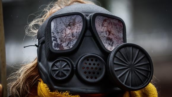 Una persona usa una máscara de gas mientras la gente protesta frente a la embajada iraní en el Día Internacional de la Mujer en Bruselas, Bélgica, el 8 de marzo de 2023. (Foto de EFE/EPA/STEPHANIE LECOCQ)